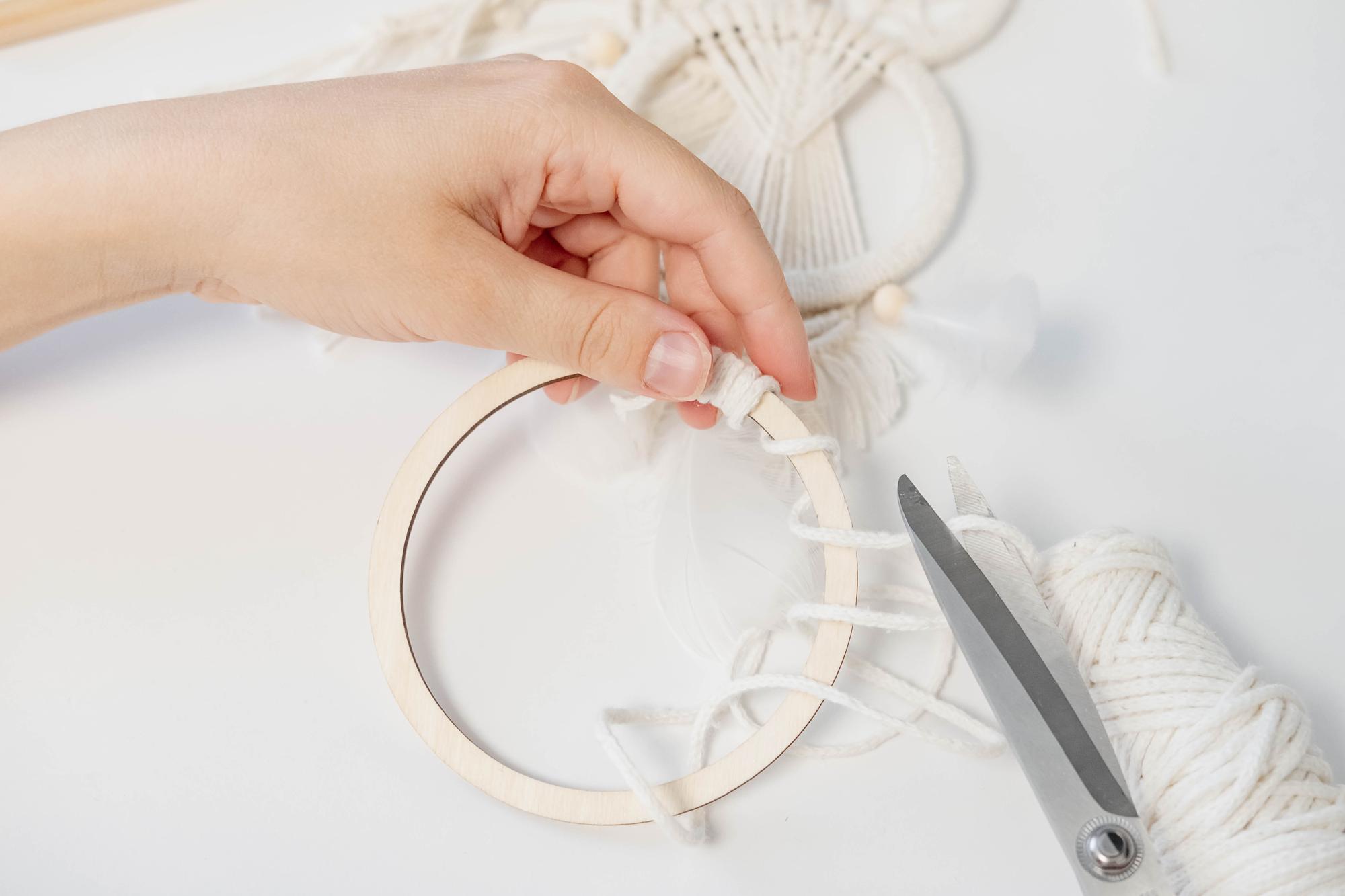 hands holding a hoop with half-completed motif